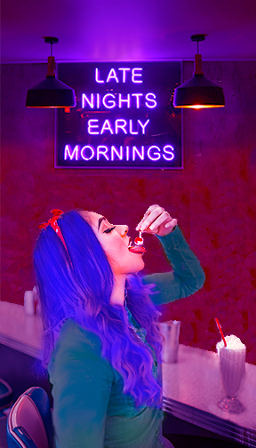 woman eating cherry under neon sign